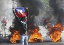 Un manifestante mostra una bandiera di Haiti durante una protesta per chiedere le dimissioni del primo ministro Ariel Henry.