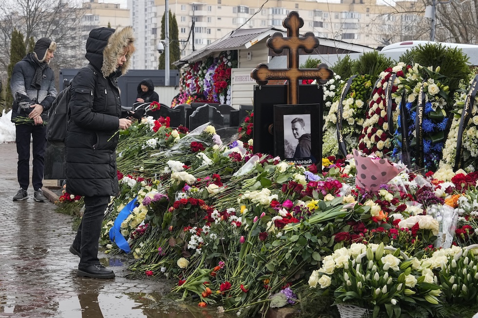 Una donna posa dei fiori sulla tomba di Alexei Navalny, morto in un carcere di massima sicurezza Siberia lo scorso 16 febbraio, il giorno dopo i suoi funerali