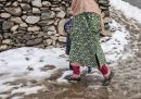 Una donna accompagna un bambino che si nasconde dietro al suo vestito a fare il vaccino contro la poliomielite