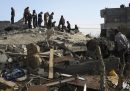 Alcune persone guardano un edificio distrutto da un bombardamento israeliano