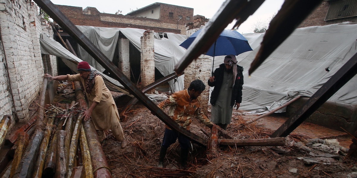 Persone recuperano le loro cose da una casa crollata a causa delle piogge intense a Peshawar, Pakistan, 2 marzo 2024