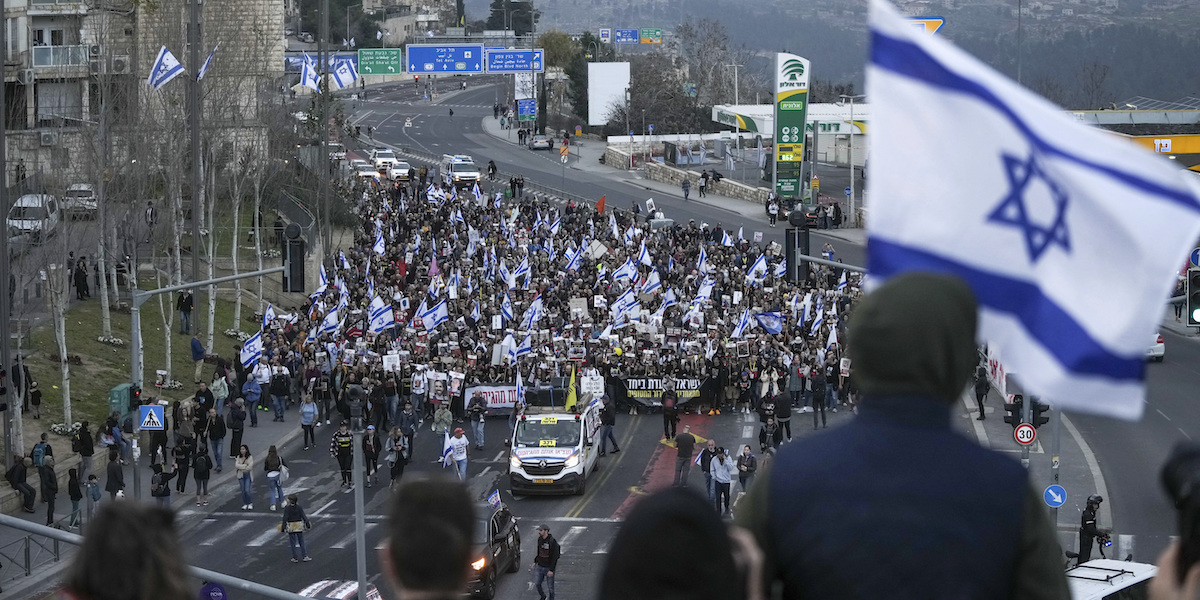 Un corteo di persone con bandiere di Israele in una strada di Gerusalemme