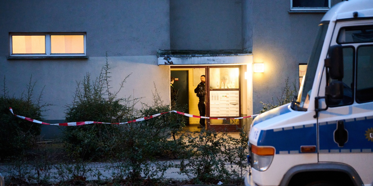 Due poliziotti nell'ingresso dell'edificio a Berlino dove si pensa che Klette abbia vissuto stabilmente dal 2007 (ANSA/Annette Riedl/dpa)