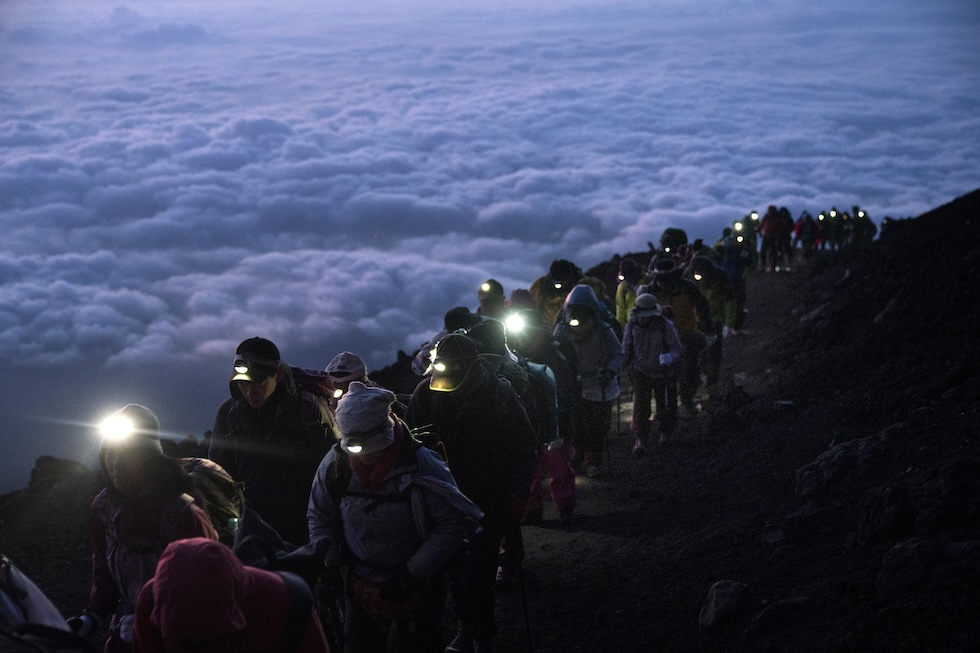 Un gruppo di visitatori durante la salita sul Monte Fuji prima dell'alba, il 27 agosto del 2019