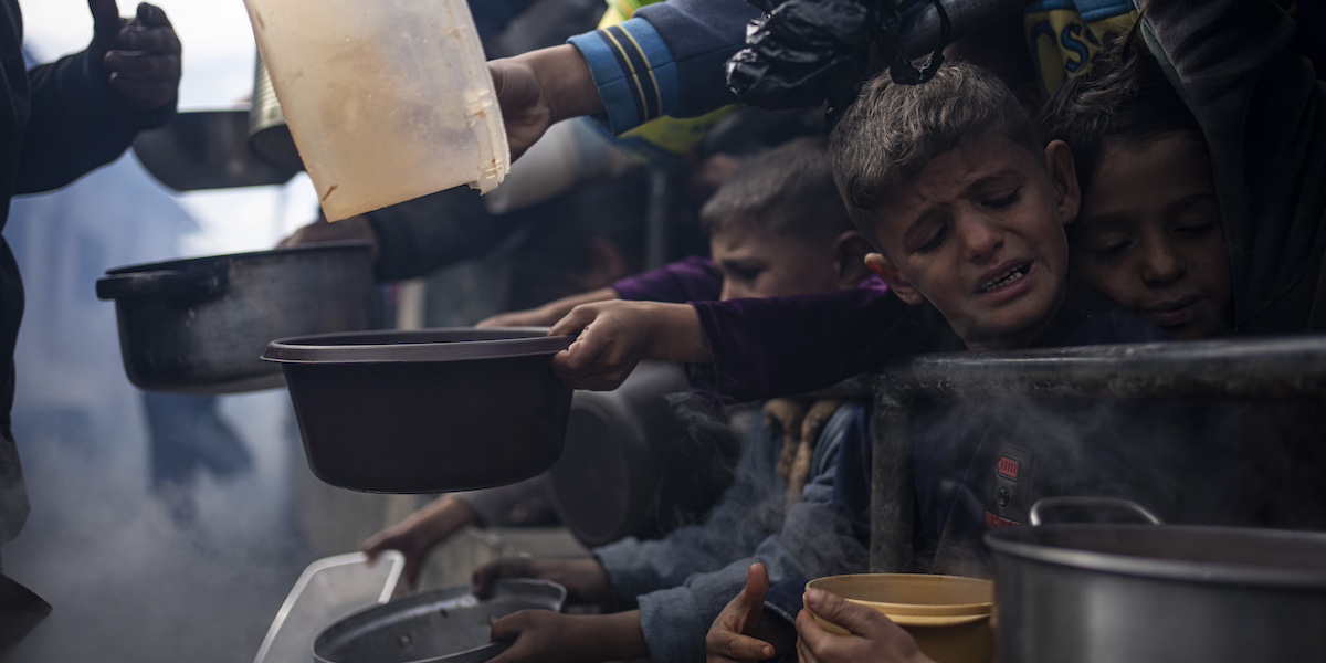 Civili palestinesi in fila per un pasto a Rafah, nel sud della Striscia di Gaza