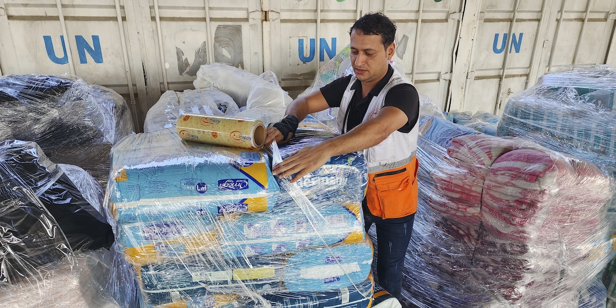 Un'operatore delle Nazioni Unite maneggia alcuni pacchi di aiuti per la popolazione palestinese