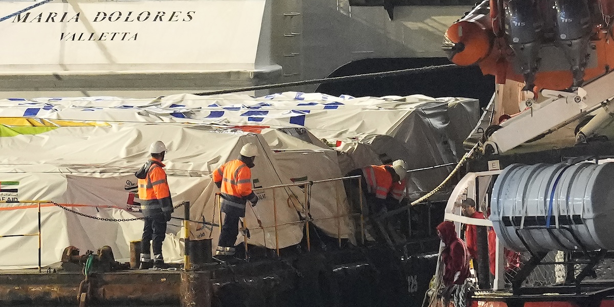 Operatori al lavoro per caricare la nave con gli aiuti che dovrebbero arrivare nella Striscia di Gaza