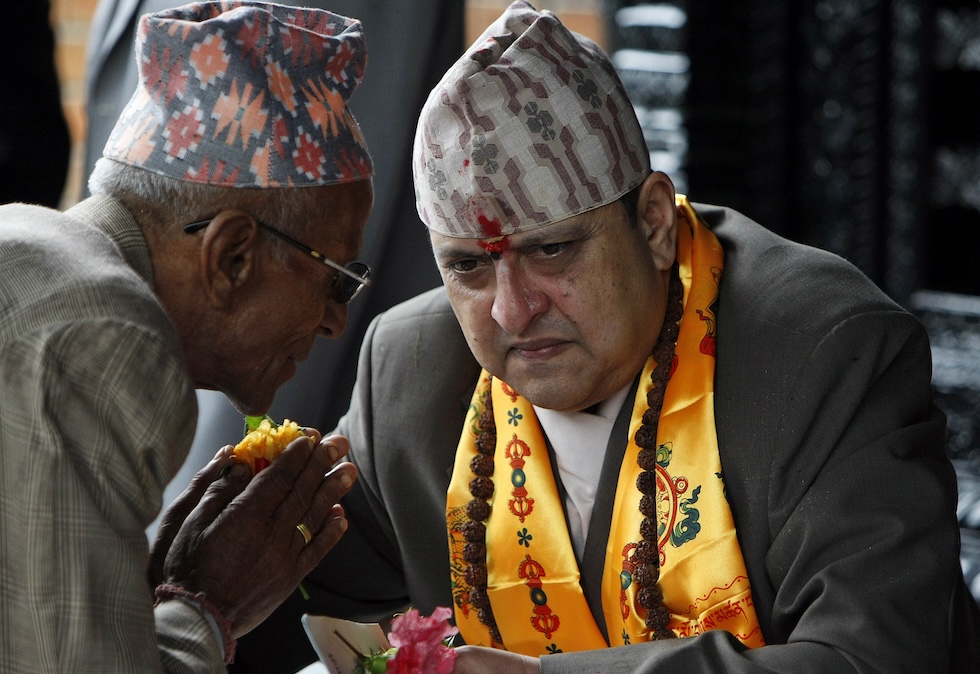 L'ex re Gyanendra, sulla destra, ascolta una persona durante le celebrazioni per il suo 64esimo compleanno a Katmandu, nel 2011