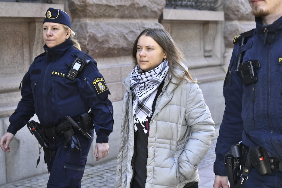 L'attivista ambientalista Greta Thunberg portata via dalla polizia durante una protesta davanti al parlamento svedese