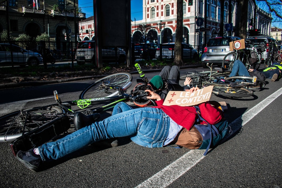 Attivisti sdraiati per terra accanto alle loro biciclette durante una manifestazione di protesta contro la riforma del codice della strada