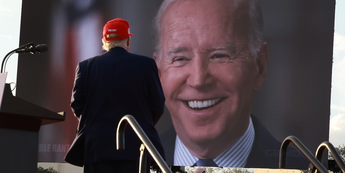 Donald Trump durante un comizio nel 2022 davanti a uno schermo che proiettava un video di Joe Biden (Joe Raedle/Getty Images)