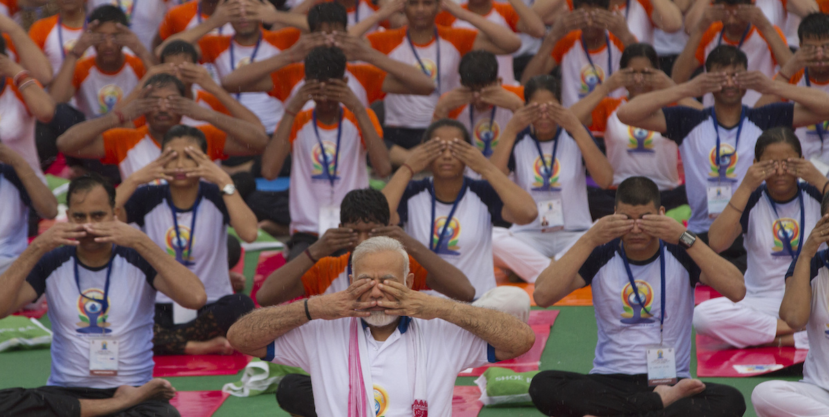 Il primo ministro indiano Narendra Modi, davanti, pratica yoga durante la giornata internazionale dello yoga, nel 2017