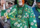 Un uomo con una maglia verde piena di spille alla parata di New York