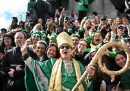 Un uomo che indossa un costume religioso è in posa insieme alle persone che partecipano alla parata di Dublino