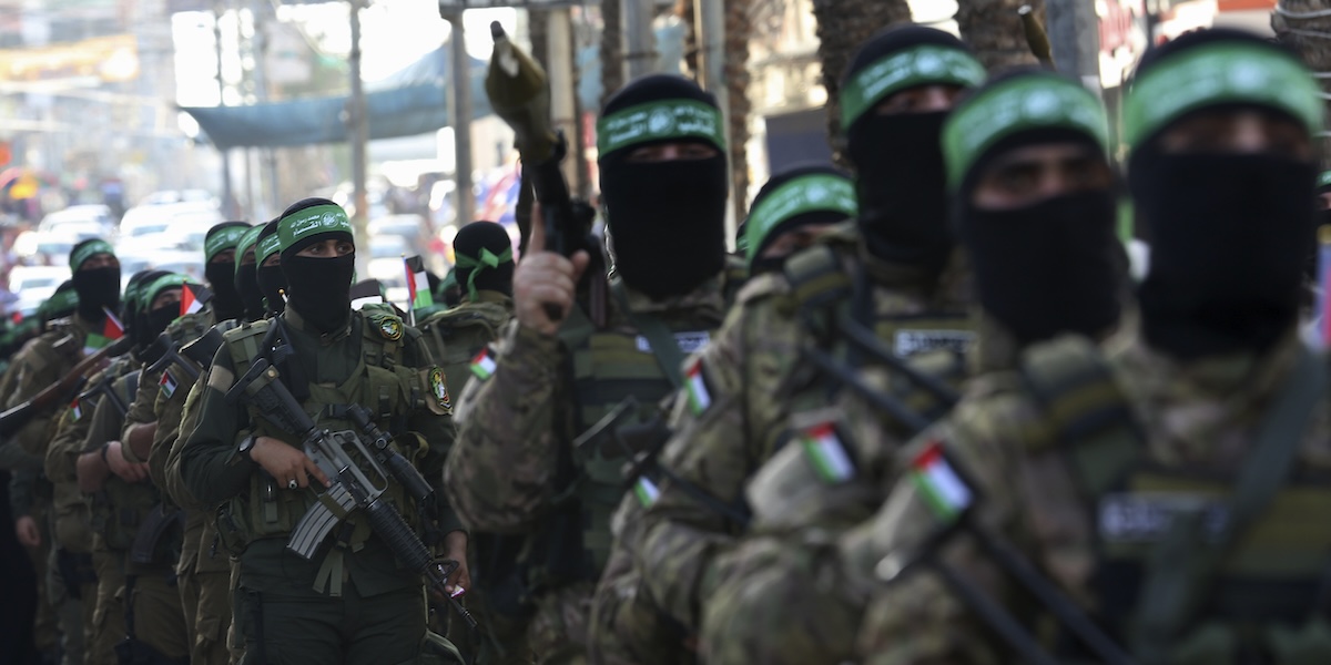 Membri delle brigate al Qassam con il volto coperto marciano nel campo profughi di Nuseirat il 28 maggio del 2021