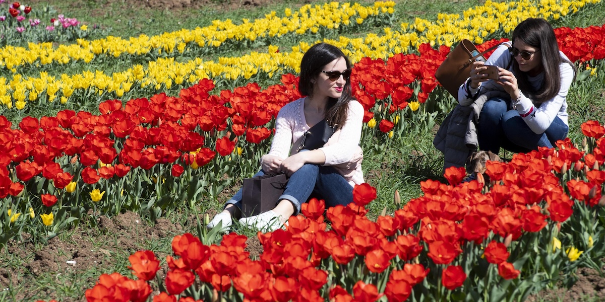 Una ragazza si fa scattare una foto in mezzo ai tulipani a Villa De Sanctis, Roma, 26 marzo 2019