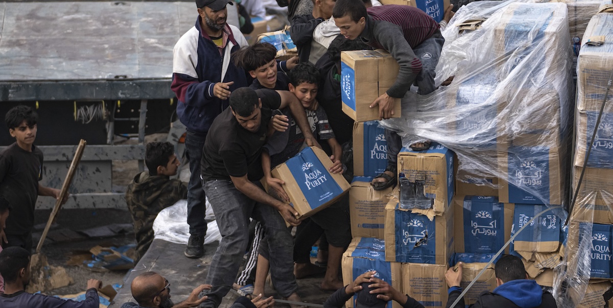 Civili palestinesi mentre ricevono aiuti umanitari nella Striscia di Gaza (AP Photo/Fatima Shbair, File)