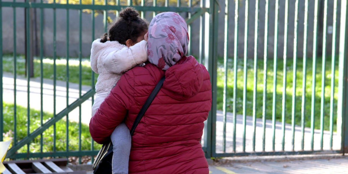 Una foto di persona con una bambina all'uscita degli alunni della scuola Iqbal Masih di Pioltello, in provincia di Milano
