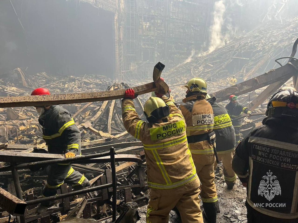 Alcuni soccorritori russi fra le macerie del teatro, completamente bruciato, sabato mattina (Servizio stampa del Ministero delle Emergenze russo via AP)