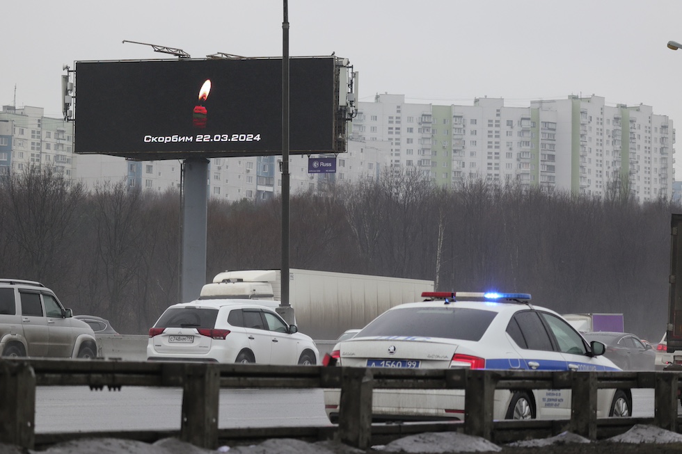Un messaggio su sfondo nero con una candela rossa che ricorda le persone uccise nell'attacco comparso al posto di vari cartelloni pubblicitari a Mosca
