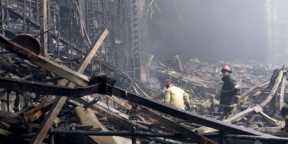 Foto di Vigili del fuoco dentro al teatro Crocus City Hall distrutto, in mezzo alle macerie