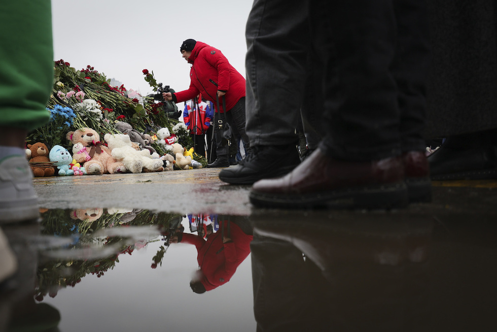 Persone che depongono fiori in memoria delle vittime dell'attacco compiuto a Mosca