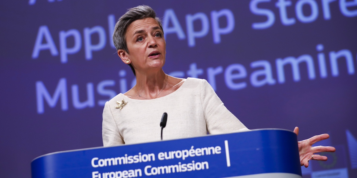 La commissaria europea per la concorrenza Margrethe Vestager su sfondo blu che parla ad una conferenza