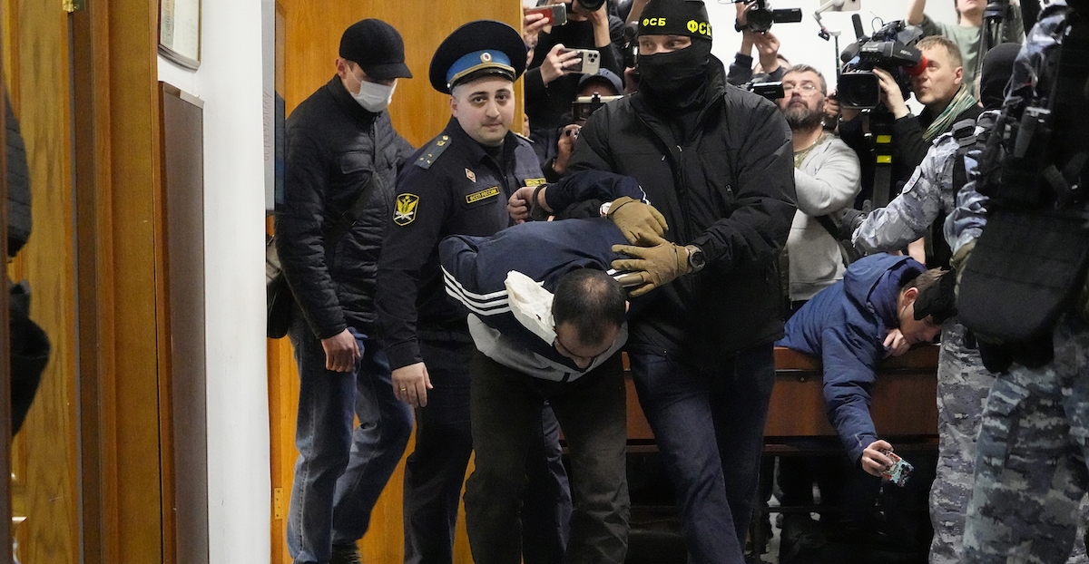 Una delle persone sospettate di aver compiuto l'attentato a Mosca mentre viene trascinata in tribunale