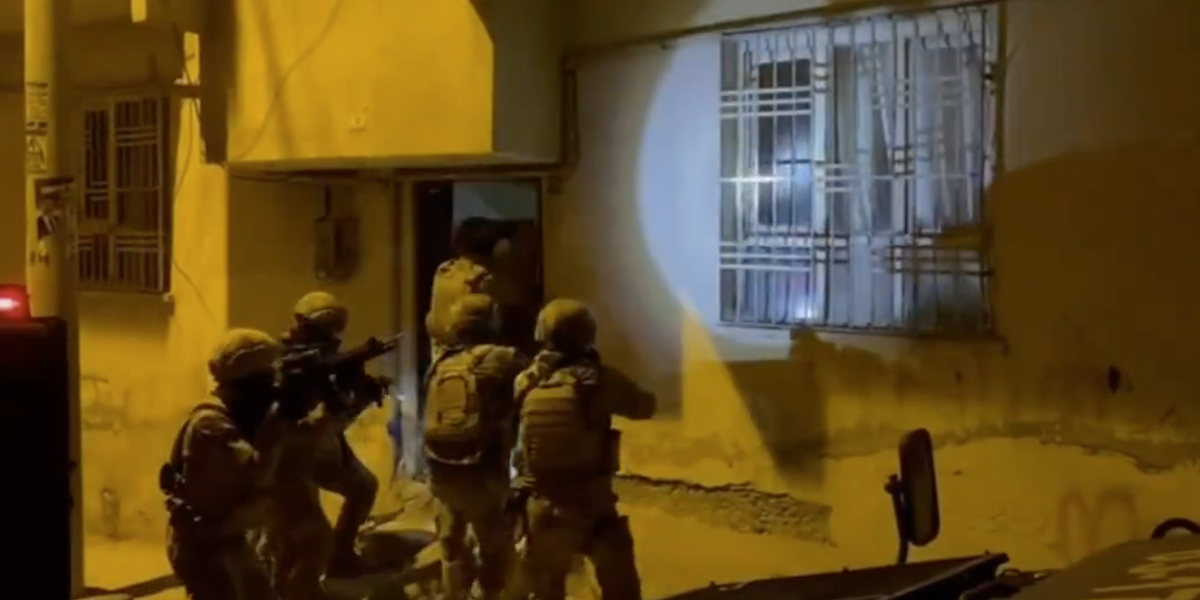 una squadra di uomini in uniforme militare entra in una casa di notte