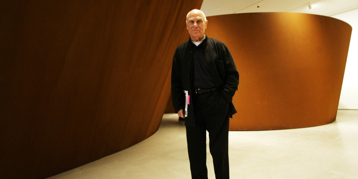 L'artista Richard Serra e dietro di lui una delle sue opere