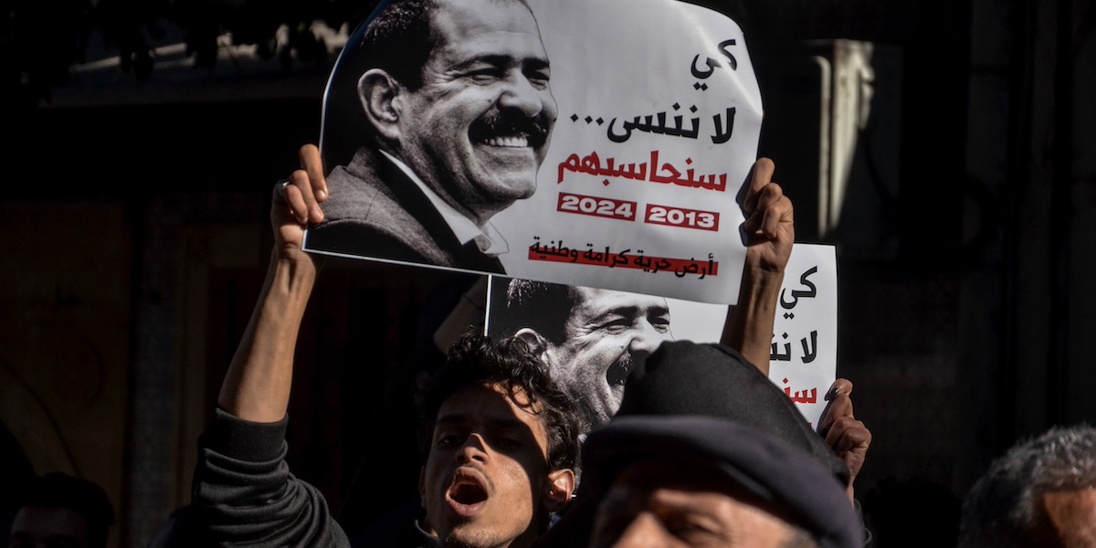 Un manifesto con il volto di Belaïd durante una sua commemorazione, a febbraio 2024 (Hasan Mrad/IMAGESLIVE via ZUMA Press Wire)