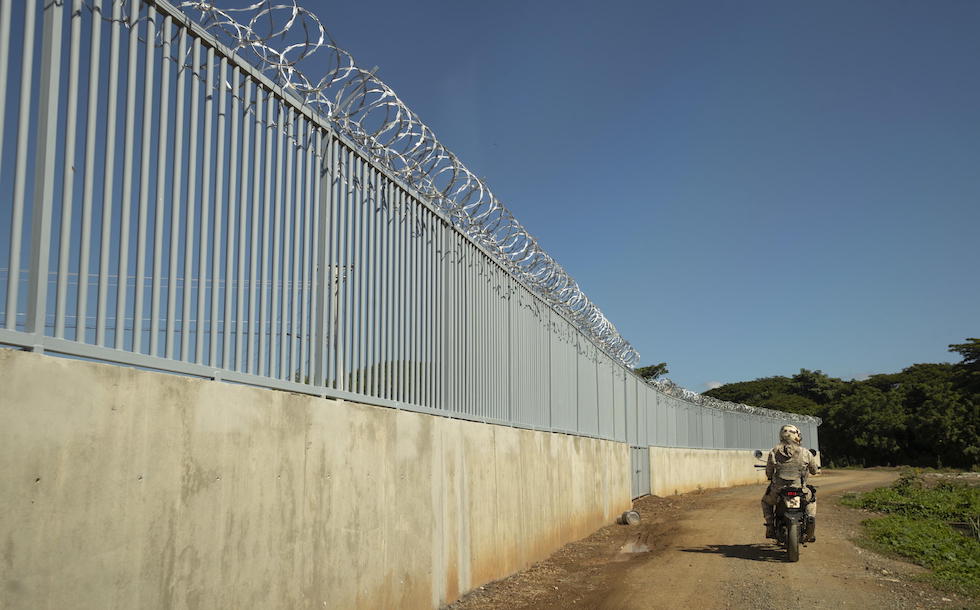 Guardie di frontiera davanti a una porzione già costruita del muro di confine a Dajabon, nel settembre del 2023 