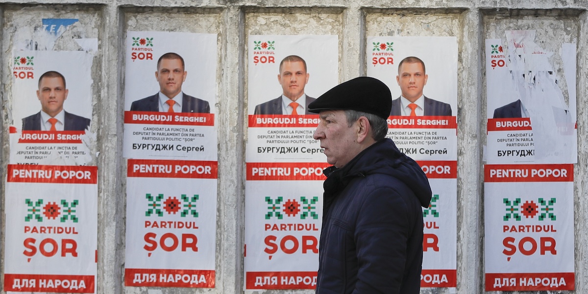 Un uomo passa davanti a dei manifesti del partito Shor a Chisinau, Moldavia, 21 febbraio 2019