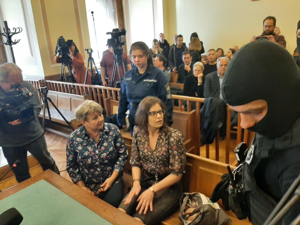 Salis seduta nell'aula di tribunale ammanettata