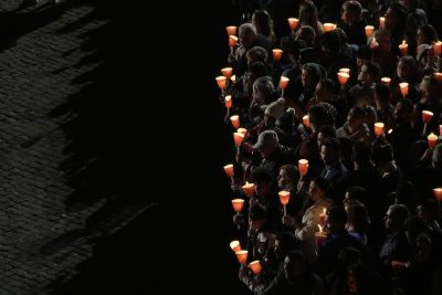Persone con candele in mano in cammino verso il Colosseo durante la Via Crucis, venerdì sera