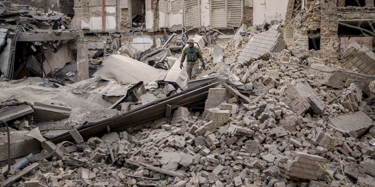 Un soldato al centro della foto cammina fra le macerie di un edificio danneggiato da un'attacco russo del 25 marzo 2024 vicino a Kiev, in Ucraina