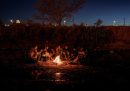 Un gruppo di persone migranti provenienti dall'Honduras si riscaldano in un accampamento al confine tra Messico e Texas, la cui controversa legge sui migranti sta facendo sta facendo incartare i tribunali statunitensi