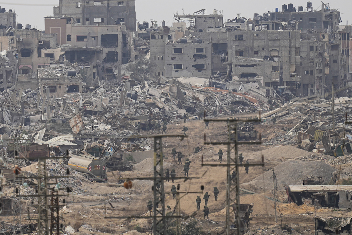 Soldati israeliani camminano nella Striscia di Gaza distrutta