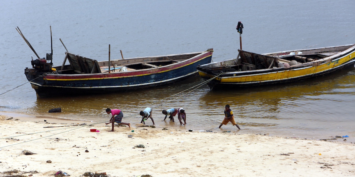 Bambini raccolgono conchiglie sulla spiaggia della città di Pemba, sulla costa nord-orientale del Mozambico