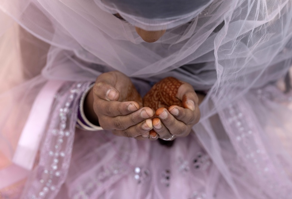 Una donna in preghiera per l'Eid al-Fitr, la festa per la fine del Ramadan, durante la quale le persone musulmane di tutto il mondo si riuniscono per preghiere e celebrazioni varie