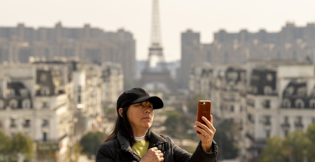 Una turista si scatta un selfie davanti alla Tour Eiffel di Tianducheng, in Cina, 17 febbraio 2024