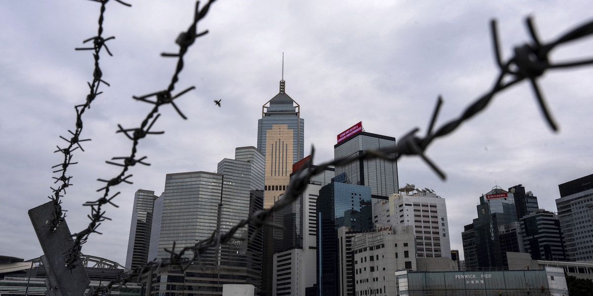 grattacieli spuntano dietro a del filo spinato a hong kong