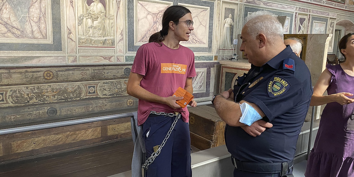 Un attivista incatenato alla transenna della cappella degli Scrovegni a Padova, durante un'azione di Ultima Generazione nel 2022 (ANSA/NICOLA FOSSELLA)