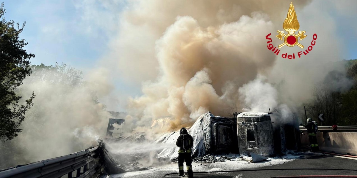 un camion coperto da schiuma antincendio e avvolto nel fumo