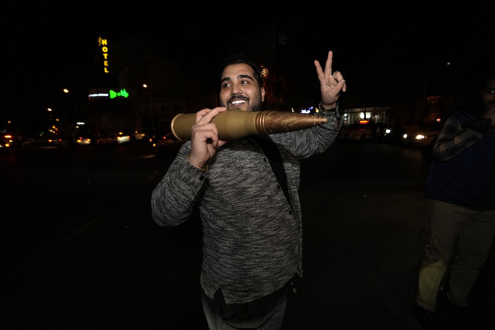 Un uomo con in mano un modellino di missile festeggia l'attacco contro Israele, a Teheran (AP Photo/Vahid Salemi)