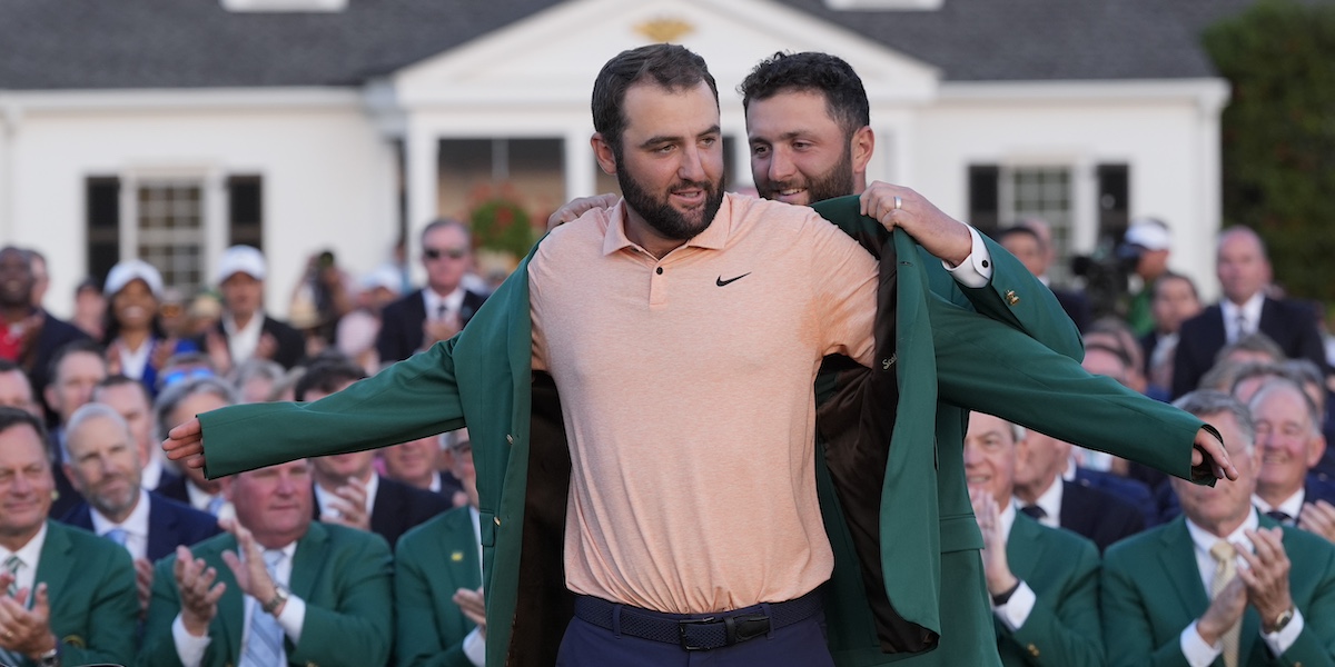 Scottie Scheffler riceve la giacca verde dei vincitori dell'Augusta Masters, come da tradizione dal vincitore dell'edizione precedente, lo spagnolo Jon Rahm (AP Photo/David J. Phillip)