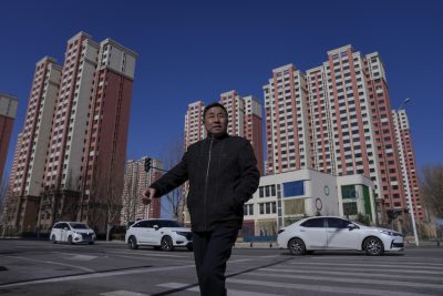 Foto di un uomo davanti a dei palazzi, a Pechino, in Cina