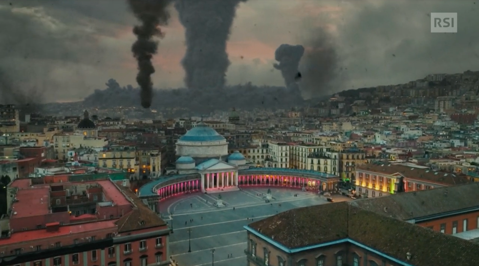 Fermoimmagine della rappresentazione grafica dei possibili effetti di un'eruzione dei Campi Fregrei su Napoli: si vede un'alta colonna di fumo nero sullo sfondo di piazza del Plebiscito