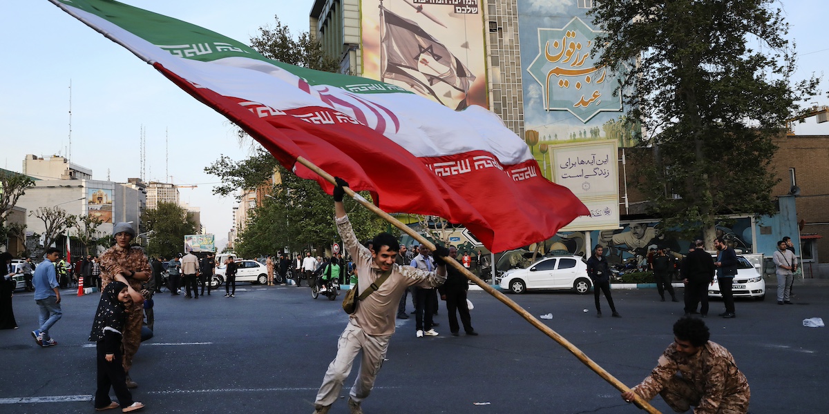 Manifestanti mostrano la bandiera iraniana a Teheran, la capitale dell'Iran (AP Photo/Vahid Salemi)