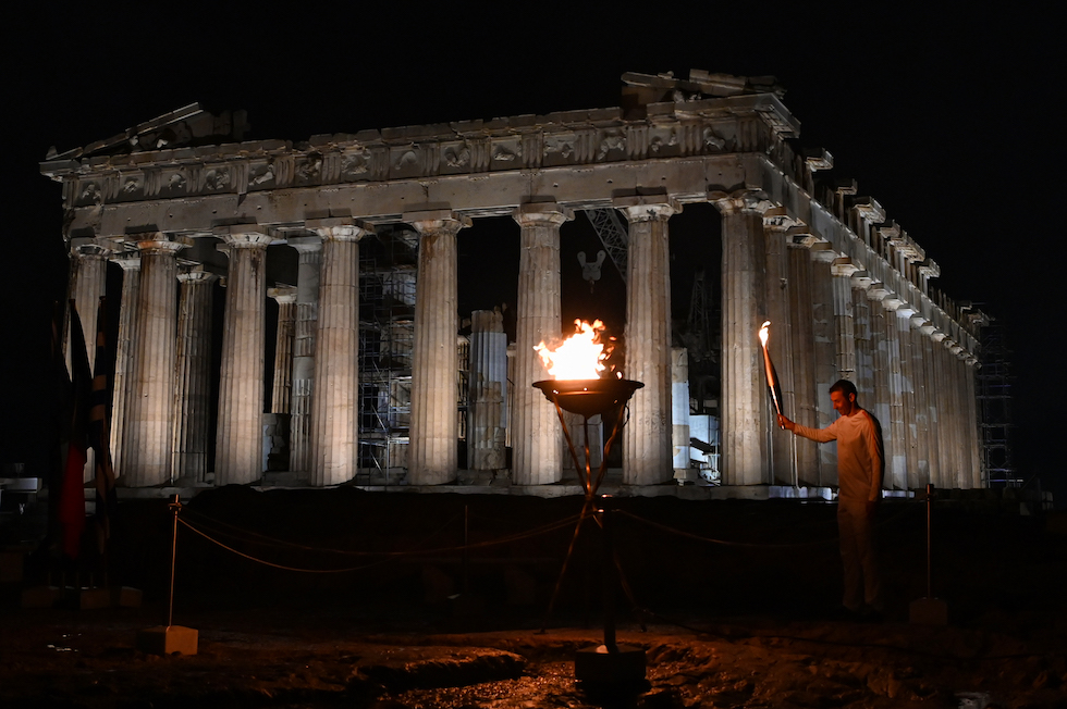 L'ostacolista greco Periklis Iakovakis accende il braciere con la fiamma olimpica davanti al Partenone in cima all'Acropoli il 19 aprile